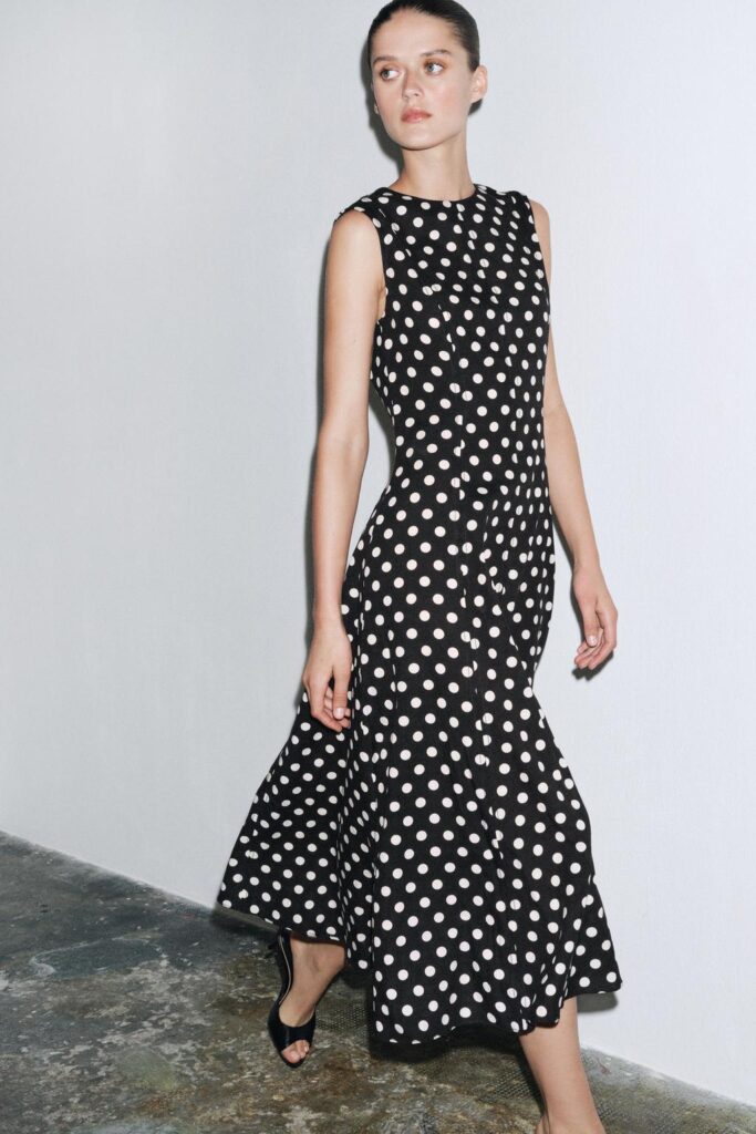 Woman wearing Zara ZW Collection sleeveless black polka dot midi dress – stylish Zara dress for this season