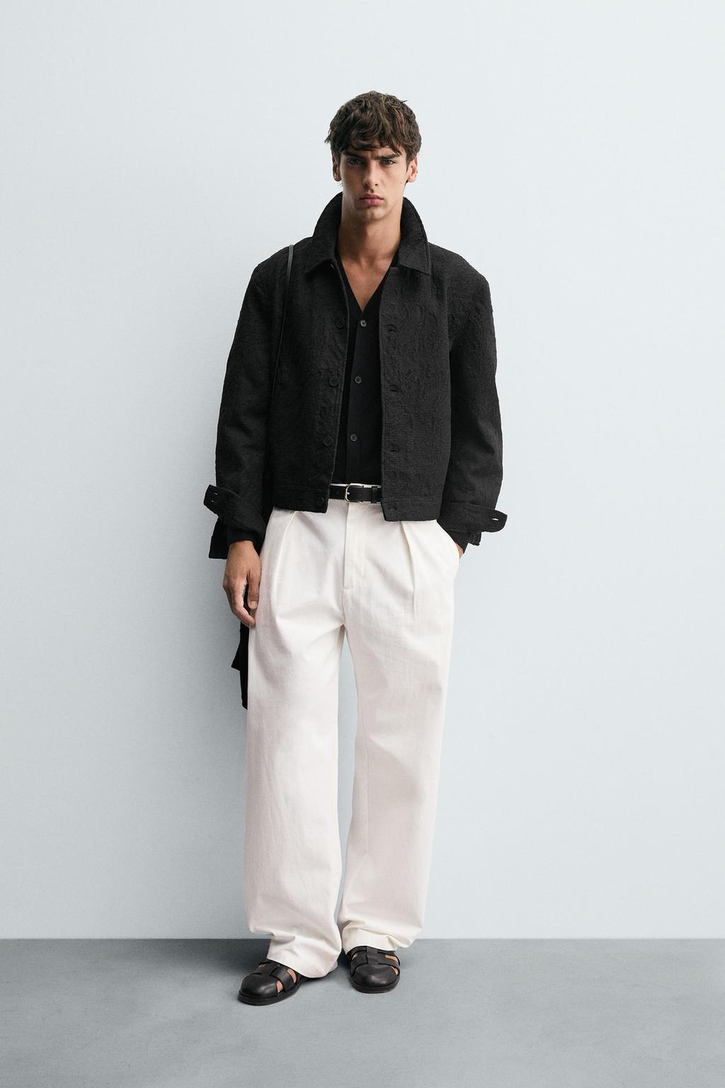 Black jacket set with a lapel collar and front pockets, wide raw-colored pants, and black sandals. 100 Best Concert Outfits Coldplay's Style