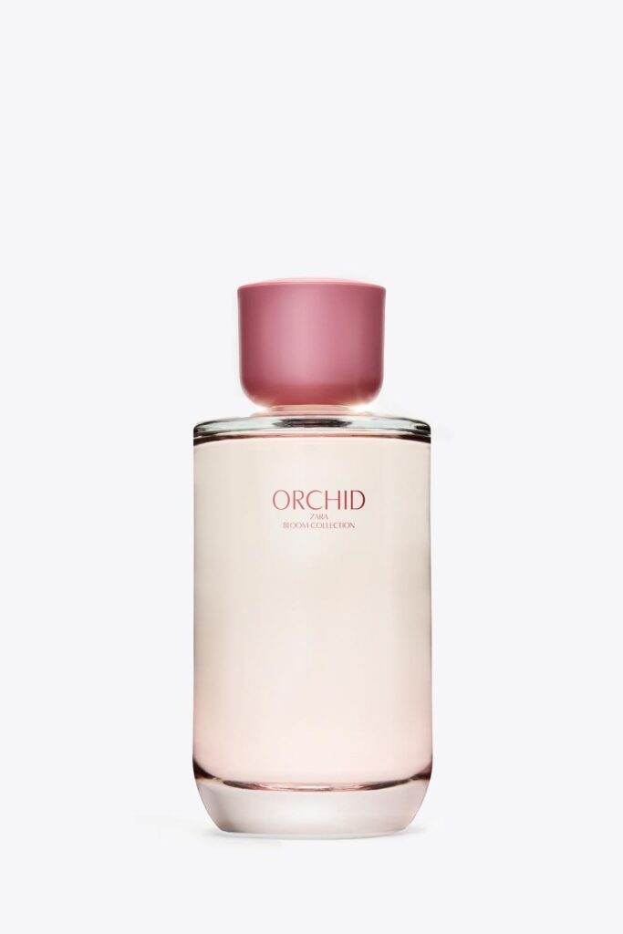 Front view of perfume bottle with pink cap and visible text "ORCHID ZARA BLOOM COLLECTION" on the transparent body.