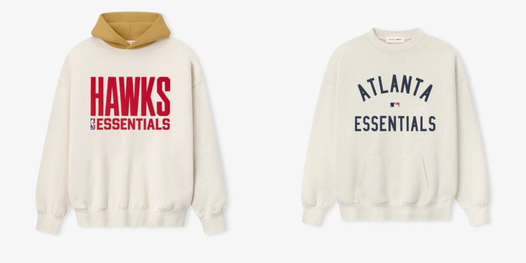 Two cream-colored sweatshirts from Fear of God Essentials featuring bold sports-inspired graphics, including “HAWKS ESSENTIALS” in red and “ATLANTA ESSENTIALS” in navy.