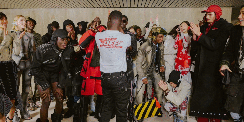 Models and performers celebrating backstage in Off-White streetwear collection.