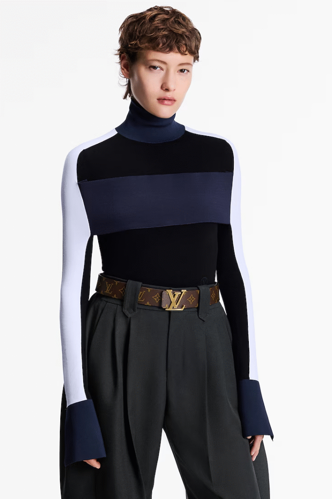 Model in a striped turtleneck top paired with wide-leg trousers and the Louis Vuitton Initiales 40mm Reversible Belt.