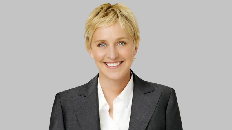 Ellen DeGeneres Wearing a Black Suit with a gray background a blog in briondi